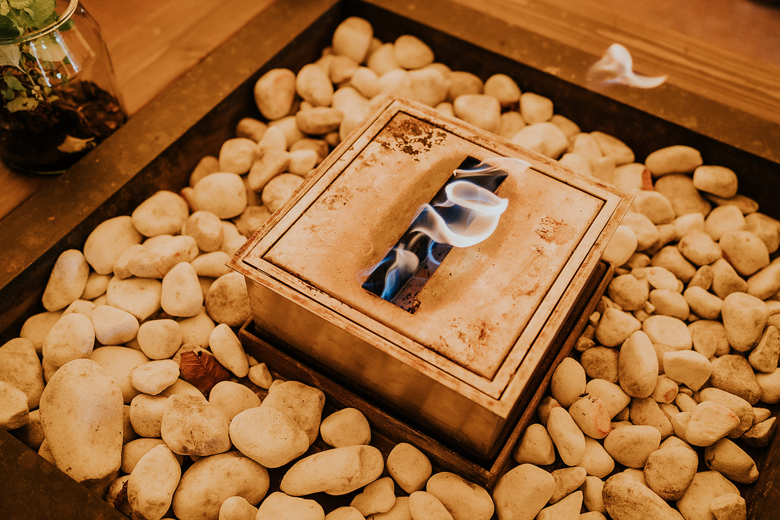 Contemporary fire pit with glowing flames set in white river stones, creating a cozy and stylish ambiance for outdoor wedding celebrations at Vallum Weddings in the Northumberland countryside.
